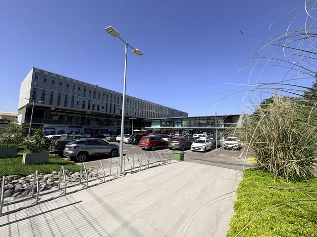 Fachada completa del edificio con estacionamientos y bicicleteros