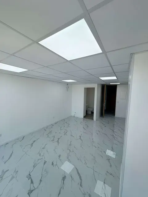 Oficina con piso tipo mármol y baño privado