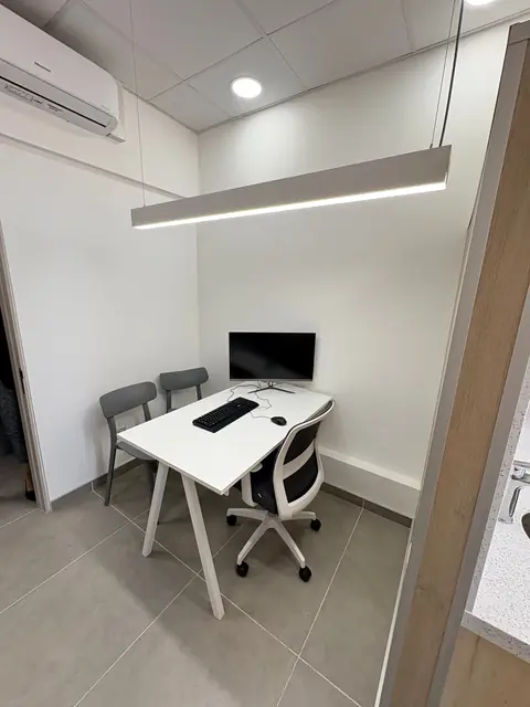 Consulta con escritorio, iluminación lineal y aire acondicionado
