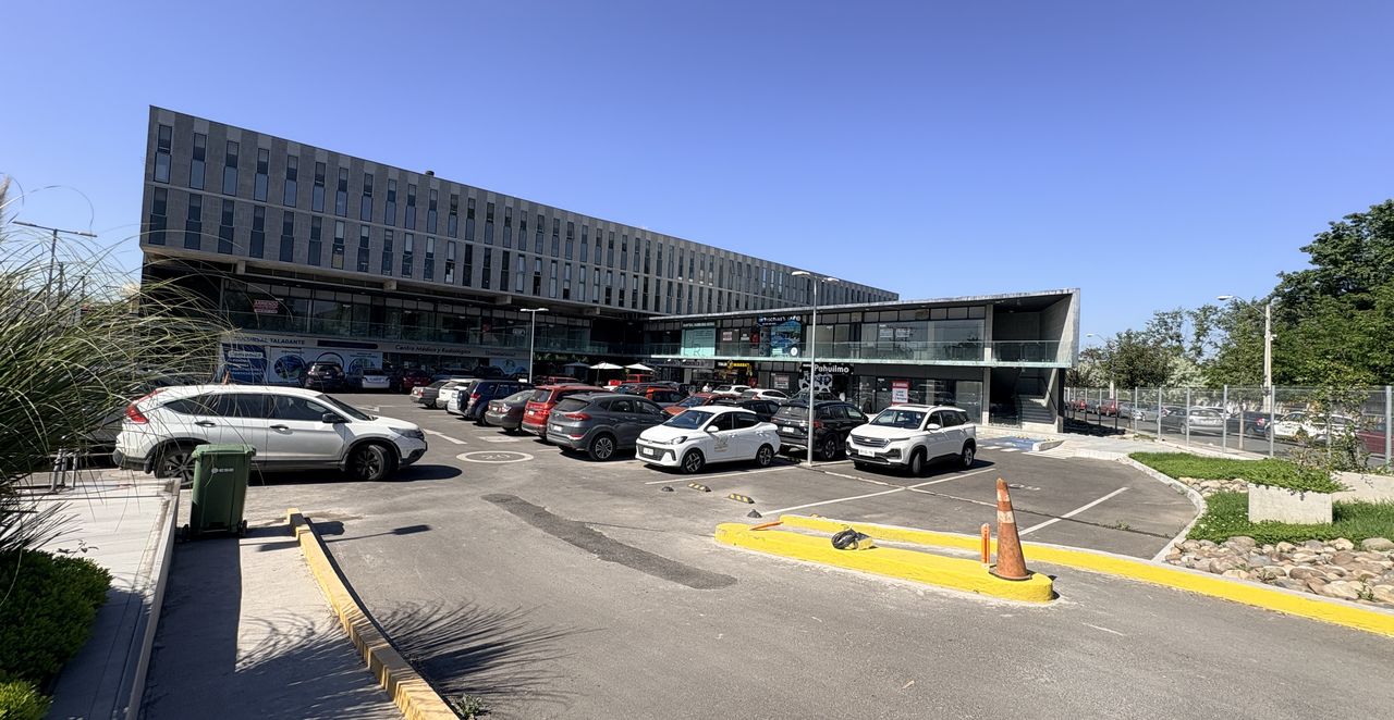 Fachada de Arenas de Talagante: edificio de oficinas sobre el strip center, con estacionamientos al frente